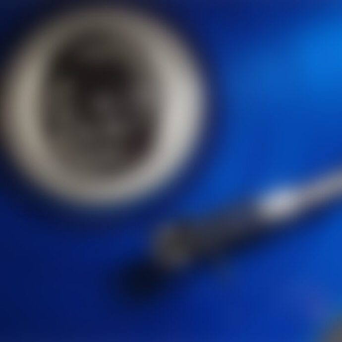 Blurry coffee cup and spoon on blue background