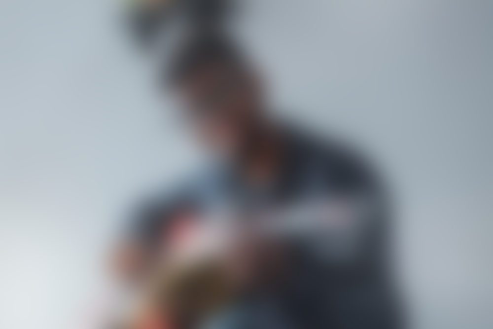 Blurry musician strumming an acoustic guitar
