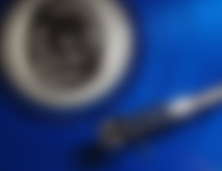 Coffee cup and spoon on blue background