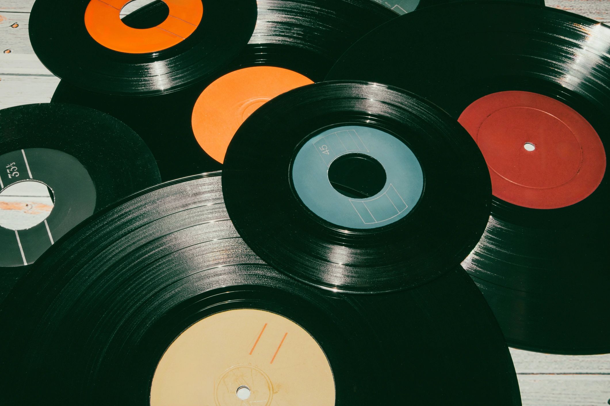 A collection of colorful vinyl records scattered on a surface.